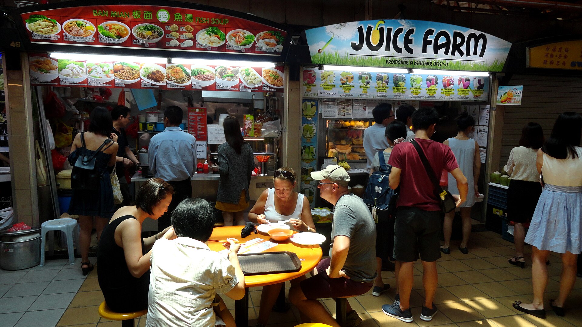 Stalls and shared tables inside a Singapore hawker centre